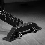 Black metal car jack on a textured gray surface